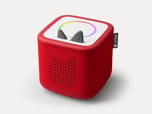 Red Toniebox 2 audio player with perforated speaker grille, gray ears, and a colorful top ring