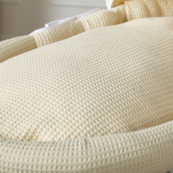 Cream waffle-textured Moses basket with woven wicker rim