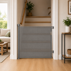 Grey fabric retractable stair gate secured across doorway opening with side posts