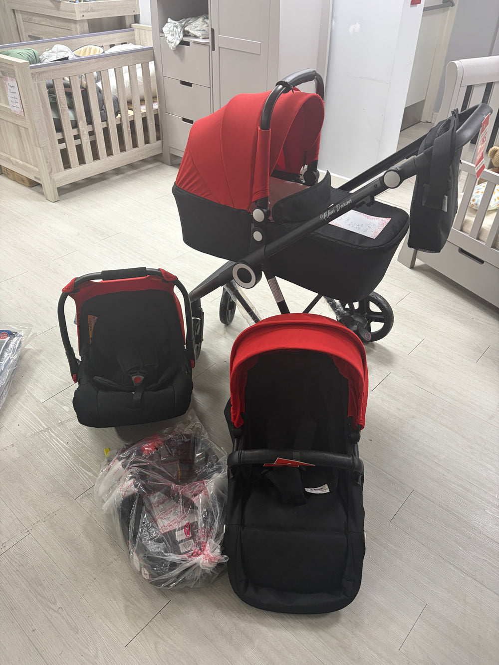 Red and black 3-in-1 baby travel system stroller with carrycot and changing bag