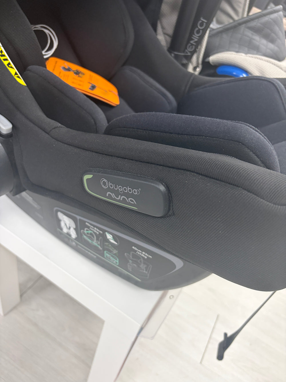 Black baby car seat with canopy, padded harness, and recline base