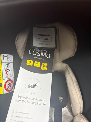 Newborn car seat with beige headrest padding and Venicci Cosmo label, product tags