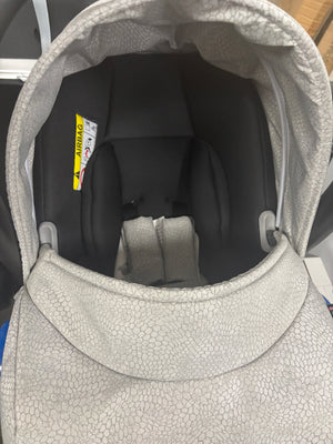 Newborn car seat with silver textured hood and black padded insert