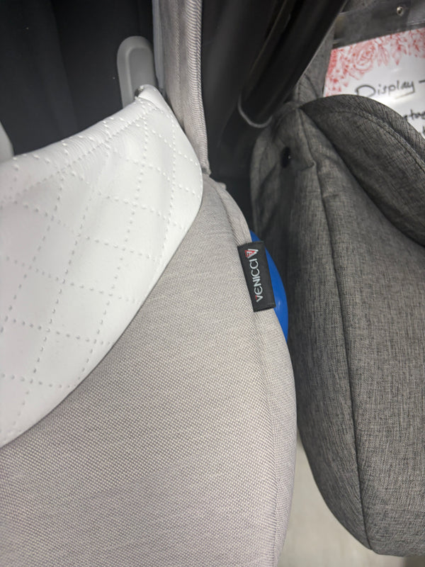 Cream newborn car seat fabric close-up with VENICCI label