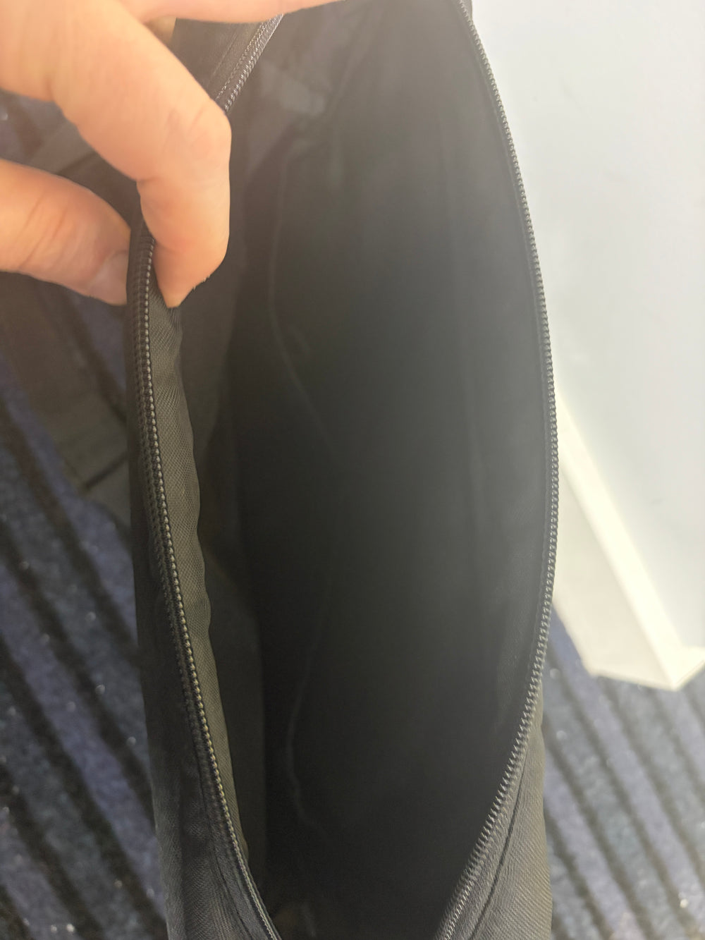 Changing bag in dark fabric with rounded front flap and zip closure