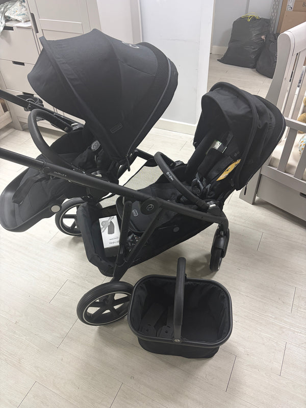 Cybex Gazelle double stroller with two black seats and shopping basket, front view