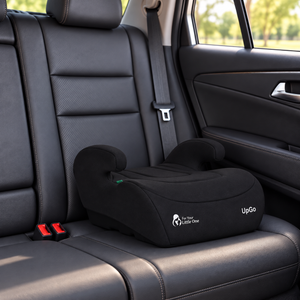 Black belted booster seat installed on car backseat with padded armrests