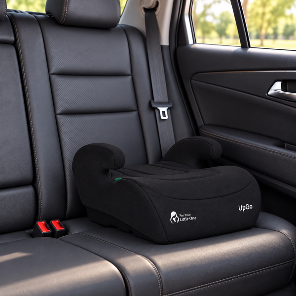 Black belted booster seat installed on car backseat with padded armrests