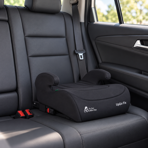 Dark booster seat installed in car seat, UpGo Fix label visible on cushion