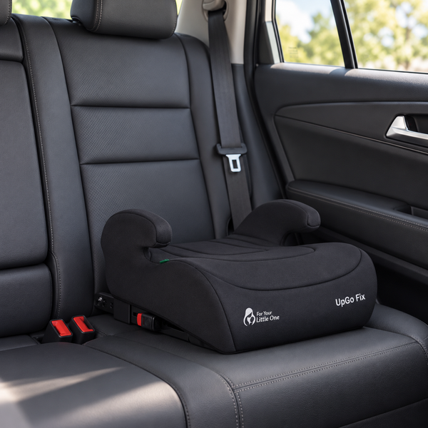 Dark booster seat installed in car seat, UpGo Fix label visible on cushion