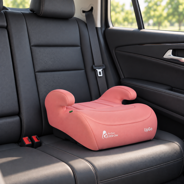 Blush rose belted booster seat installed on a car back seat with padded headrests