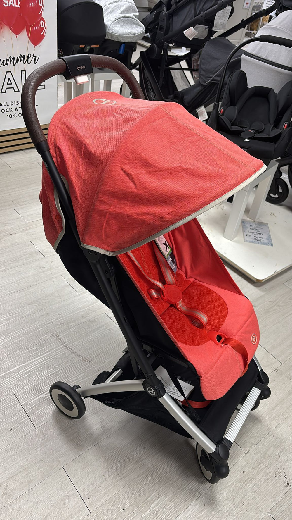 CYBEX baby stroller, hibiscus red seat and hood, black frame, front-left view
