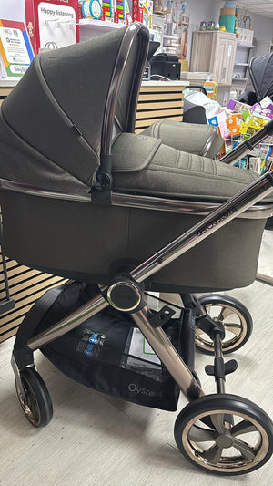 Gray stroller with toddler seat and canopy, curved handlebar, and silver multiwheel frame