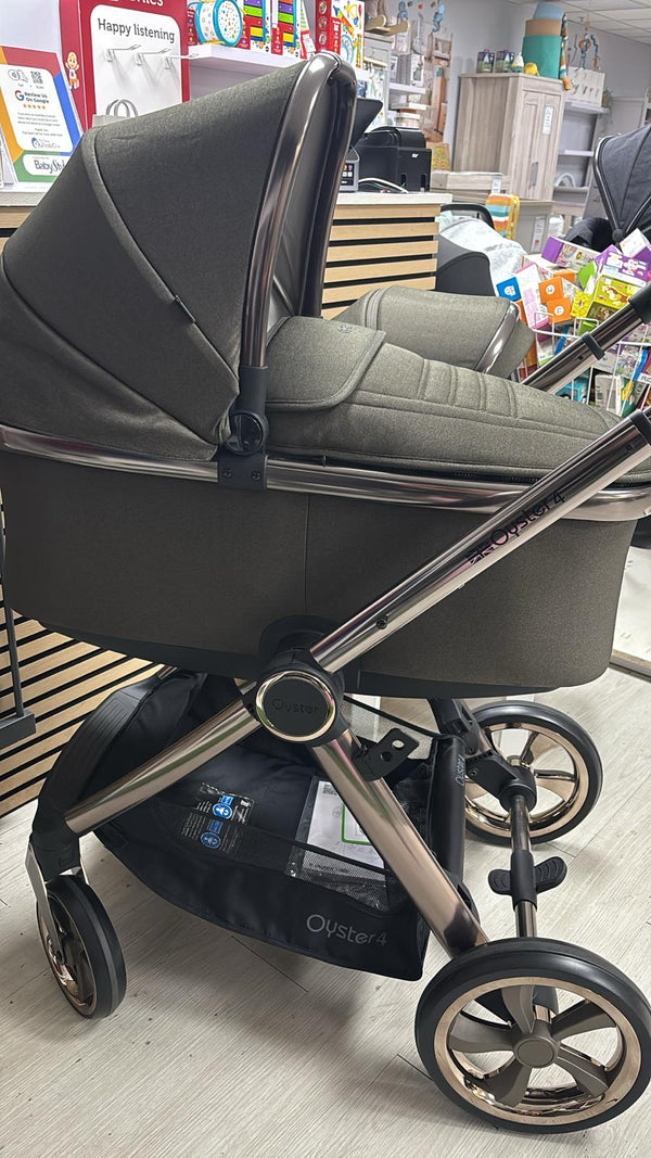Gray stroller with toddler seat and canopy, curved handlebar, and silver multiwheel frame