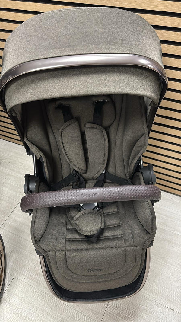 Gray stroller bassinet with canopy and padded headrest, front harness strap detail