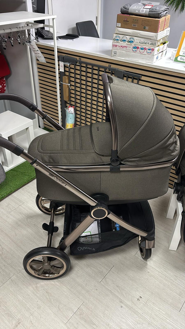 Gray stroller with bassinet and canopy, silver frame accents, and large black wheel hubs