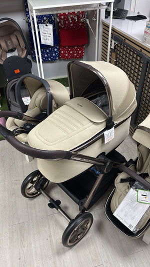 Beige 4-in-1 stroller with two seats and dark frame, showroom angle