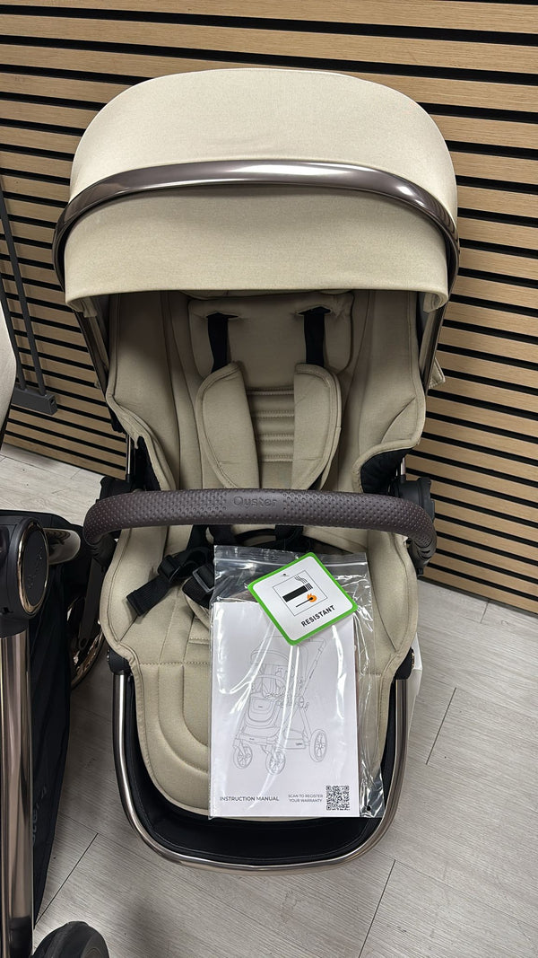 Beige stroller bassinet with hood and seat liner, front view